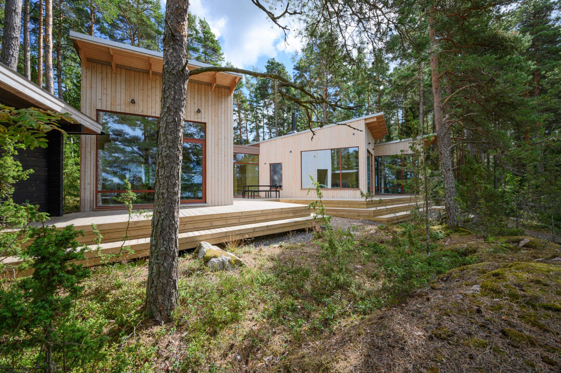 Деревянный дом 125 м² для двух семей: две постройки с общей террасой,  панорамные окна с видом на лес и море, аскетичный интерьер